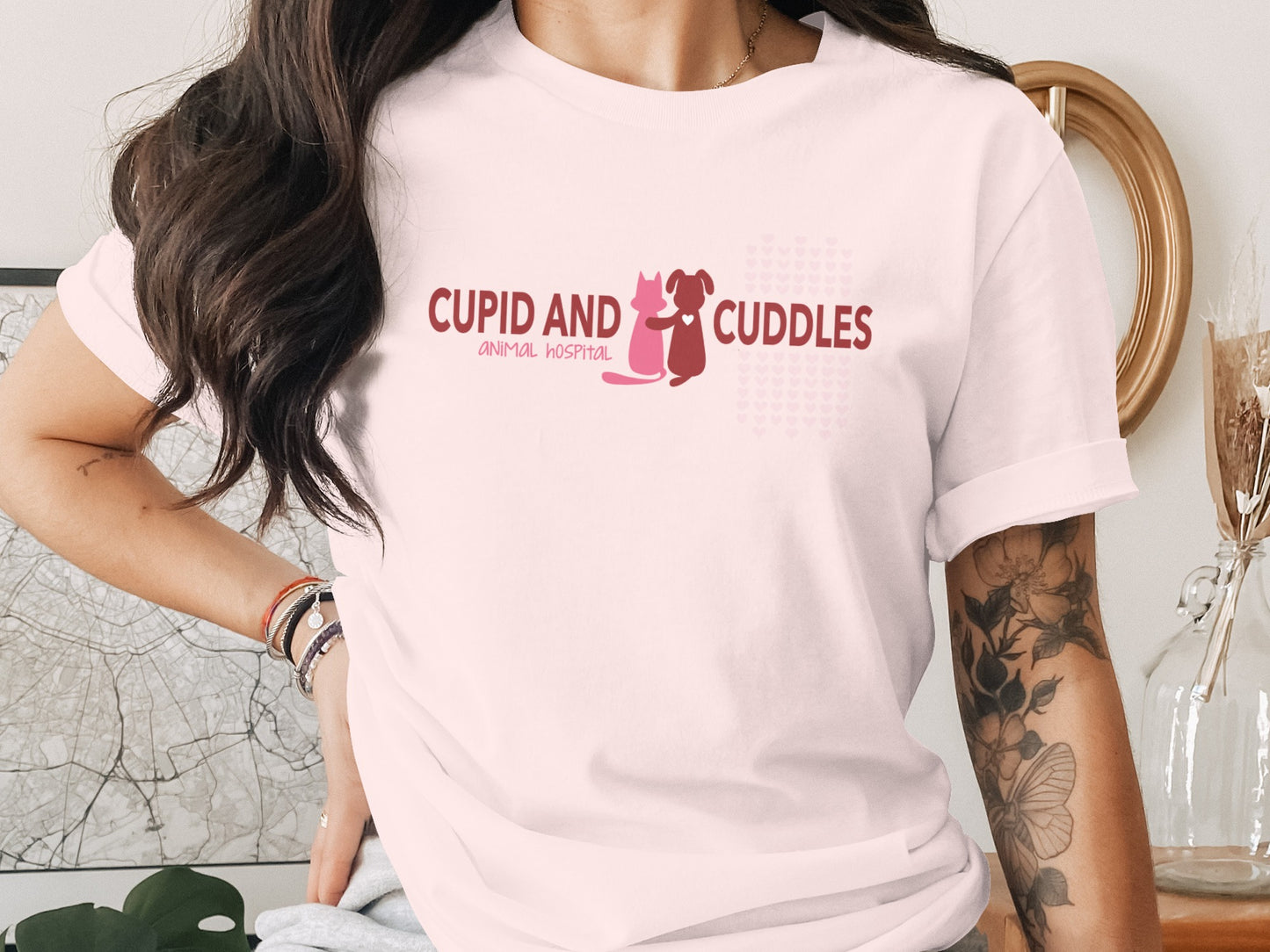 Pink t-shirt with "CUPID AND CUDDLES ANIMAL HOSPITAL" text and dog and cat icons.